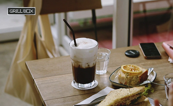 Café helado con topping de crema sobre una mesa de un local comercial