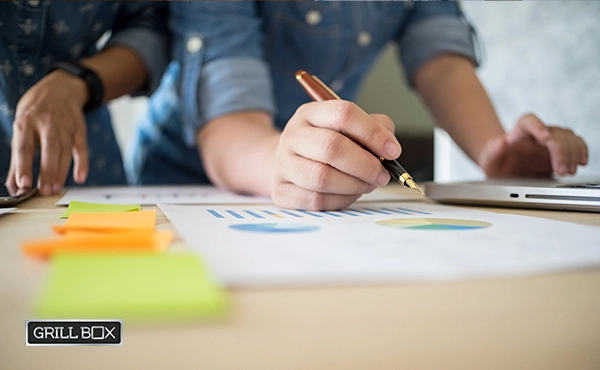 Dos emprendedores redactando un plan de negocios en un papel